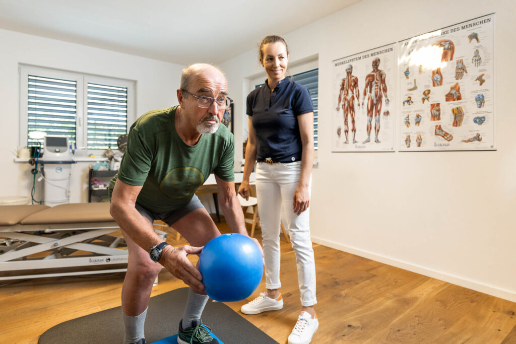 Physiotherapeutin Petra Walchhofer zeigt einem Patienten eine Übung